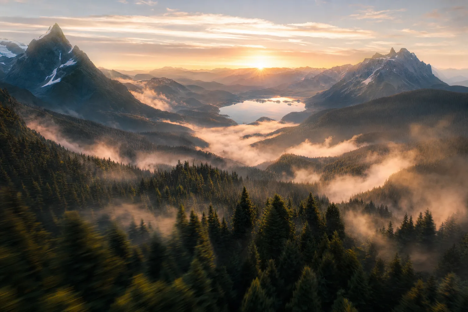 FPV drone shot flying over a misty mountain valley at sunrise, sweeping fast through pine forests toward a distant lake, epic landscape.